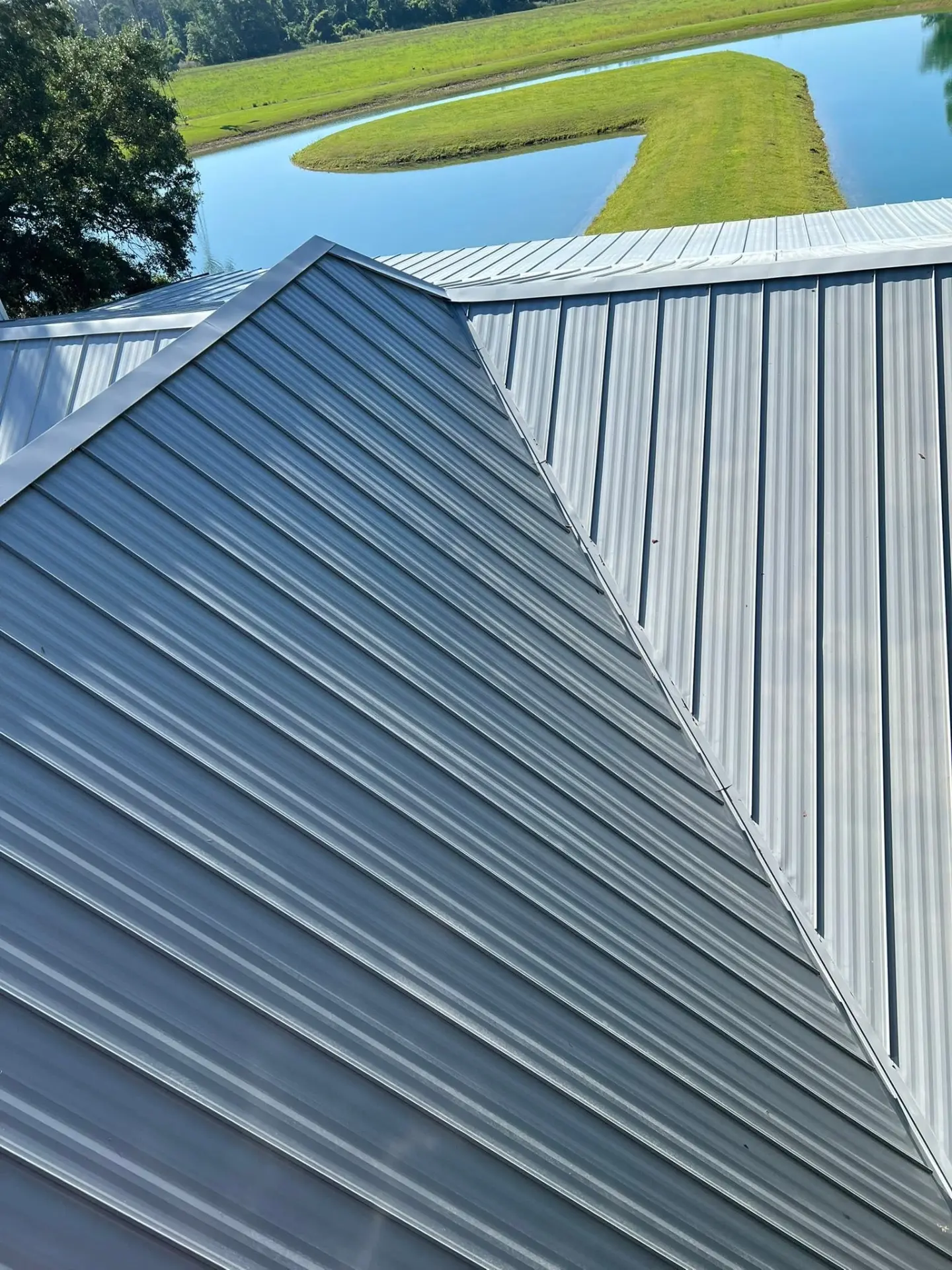 Clean white metal roof on a home overlooking a pond